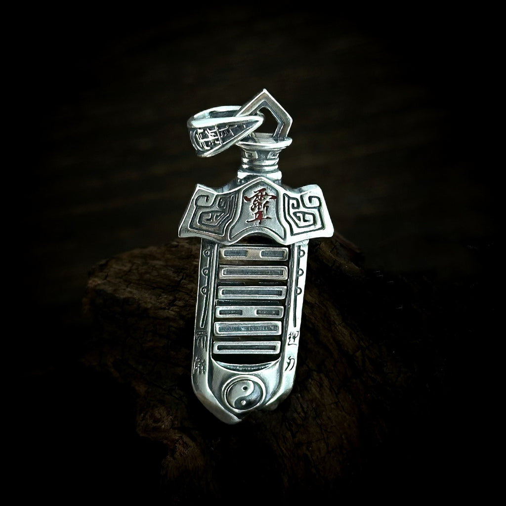 TaoWards yin-yang sword pendant shown on its own against dark wood.