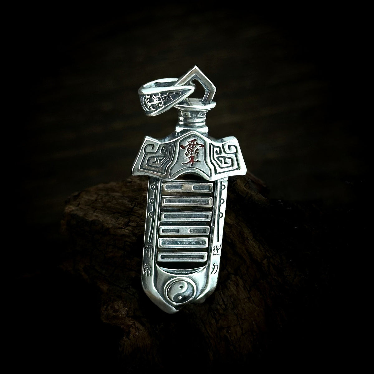 TaoWards yin-yang sword pendant shown on its own against dark wood.