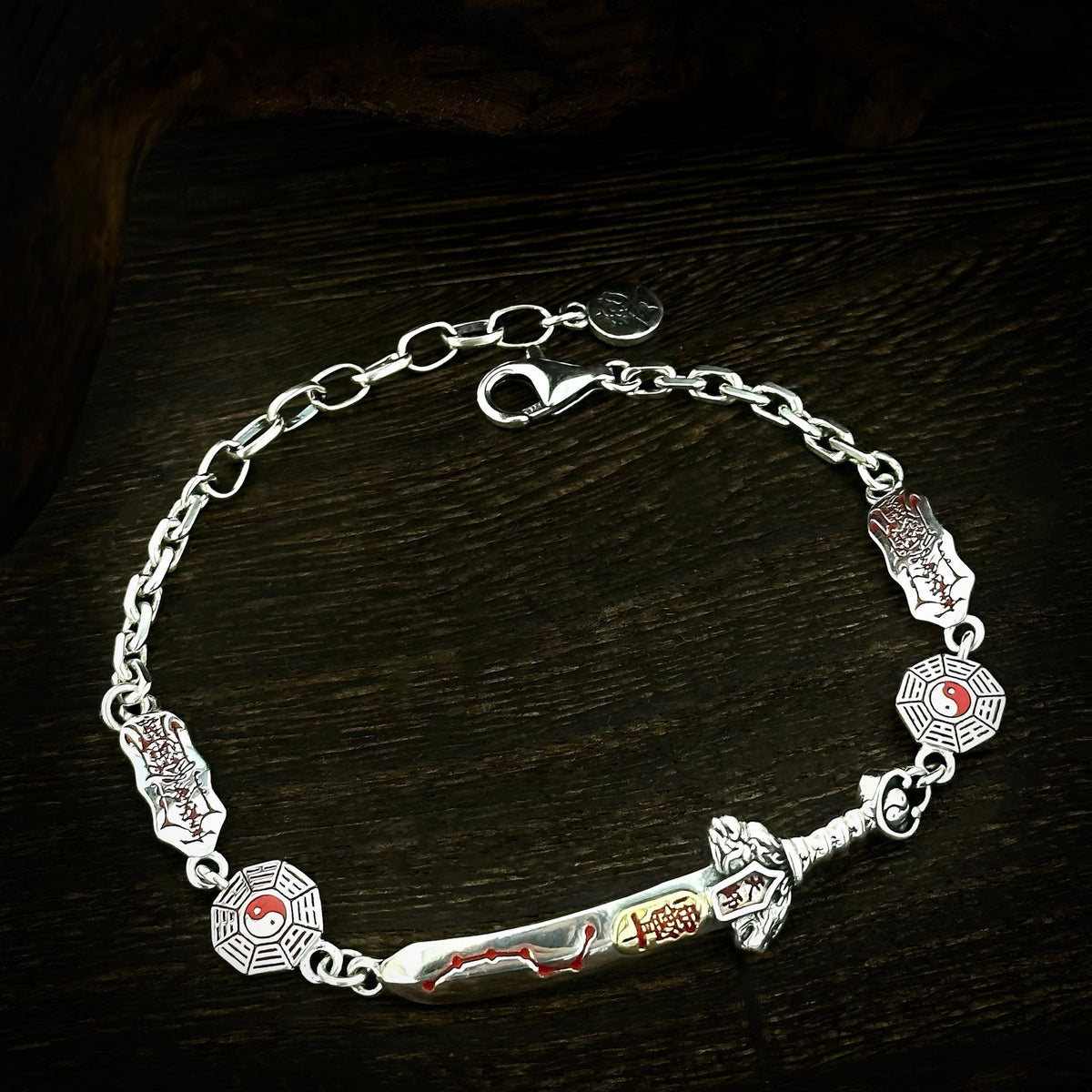 Front of the TaoWards sword bracelet showing yin-yang links and red details.