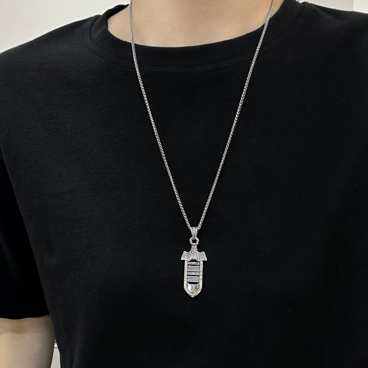 TaoWards sword pendant worn over a black T-shirt; chain not included.
