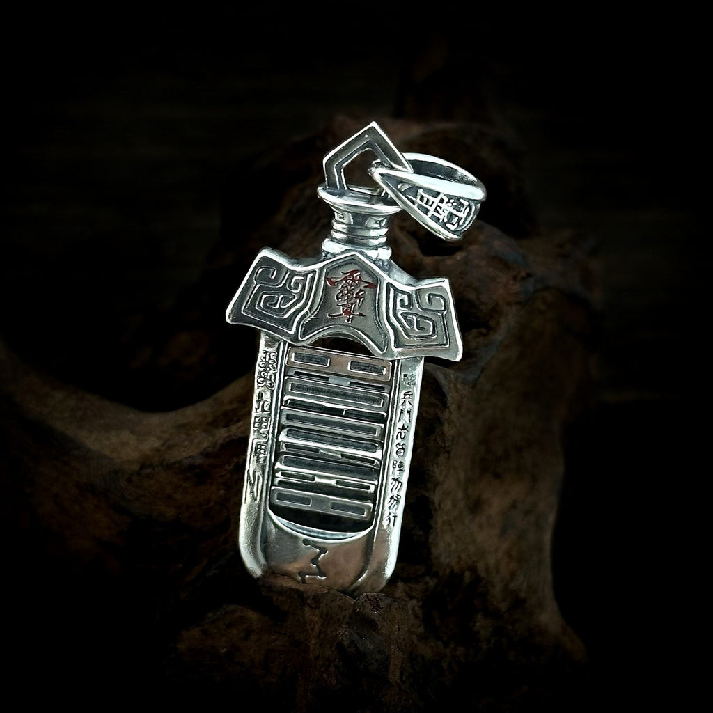 Angled view of the TaoWards sword pendant, showing openwork and recessed markings.