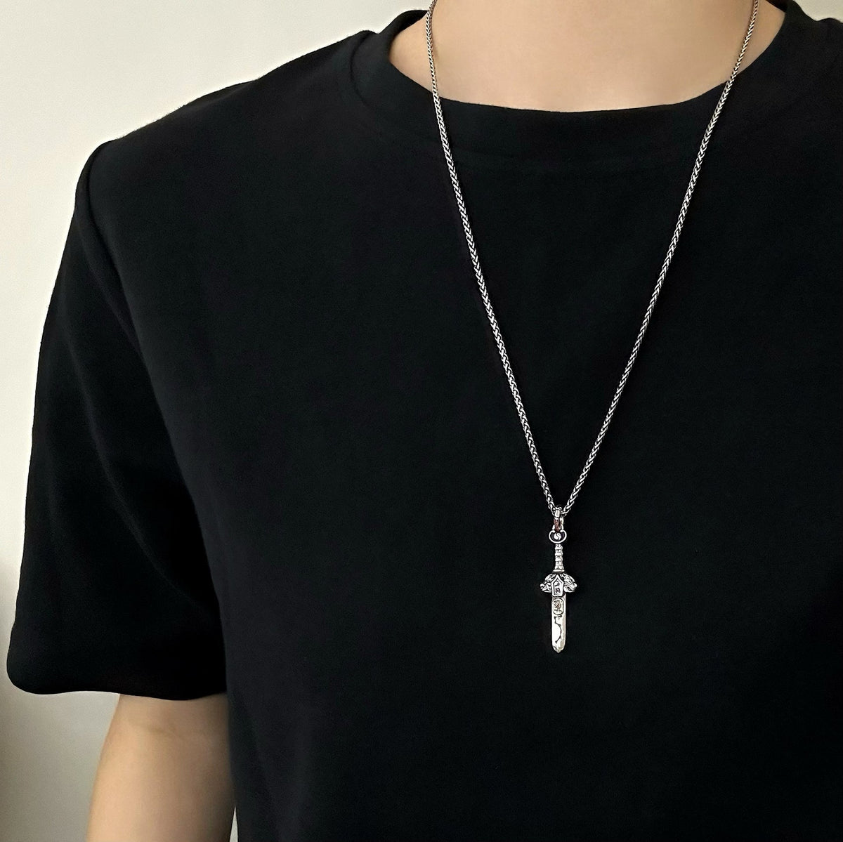 TaoWards sword pendant worn over a black shirt; chain not included