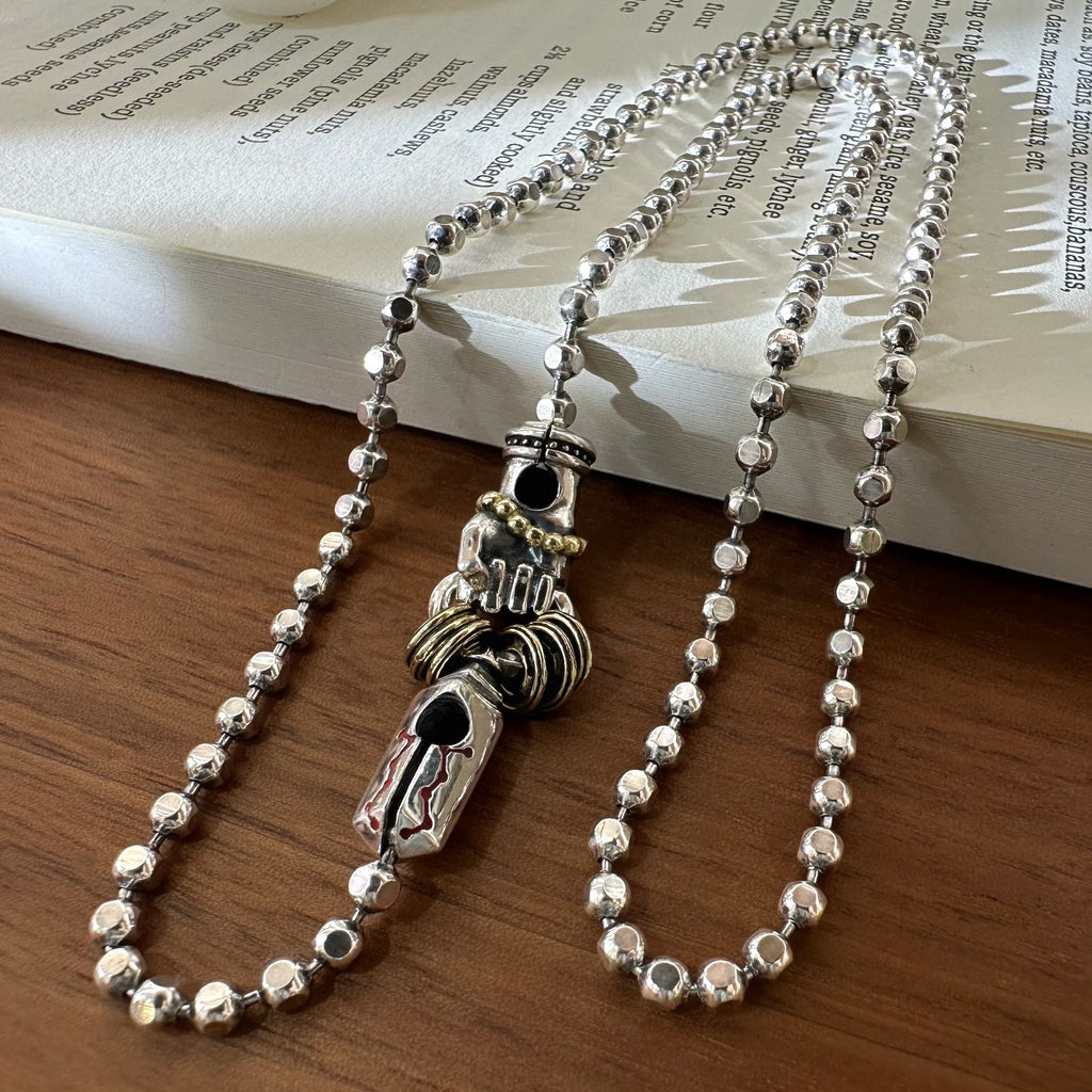 Reverse of the Daoist blade necklace showing openwork details and bead chain