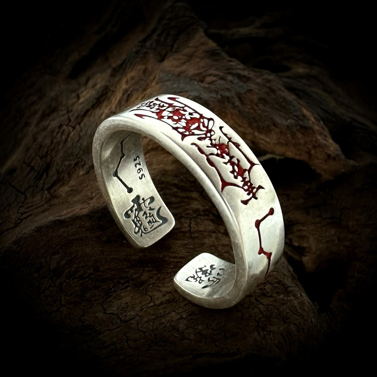 TaoWards red engraved open ring on a dark wood background