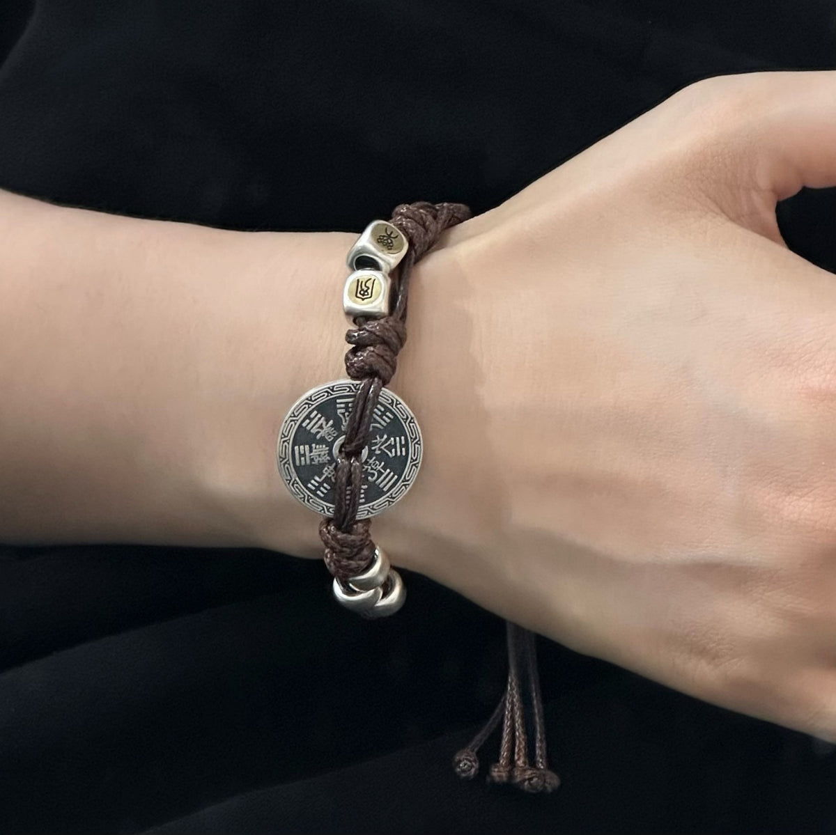 TaoWards brown cord bracelet worn with the reverse coin face visible