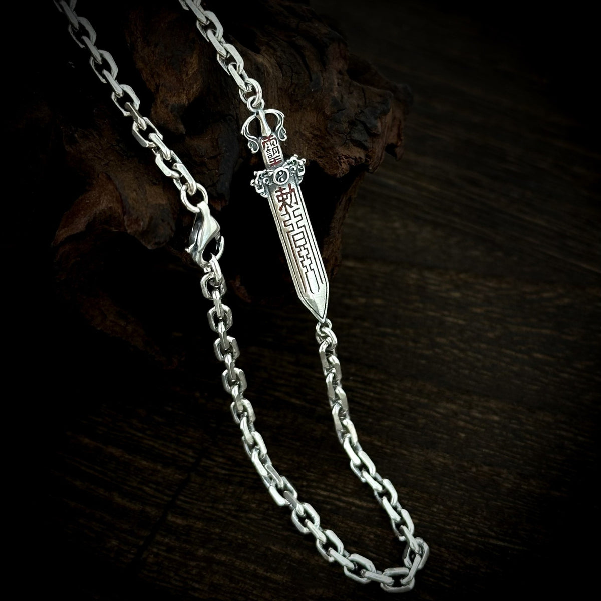 Close-up of the sword detail, angular chain links and lobster clasp on the TaoWards necklace.