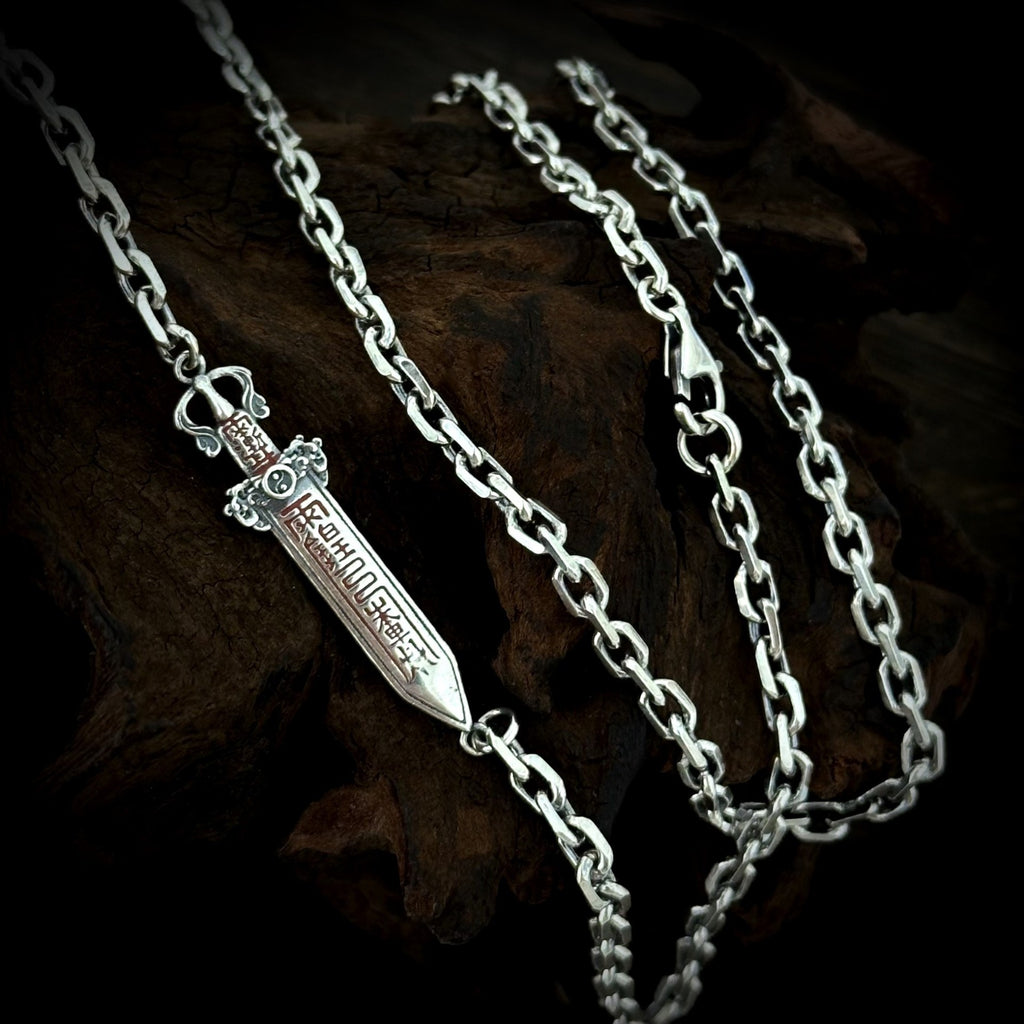 Reverse side of the TaoWards sword chain necklace, showing recessed symbolic patterns.