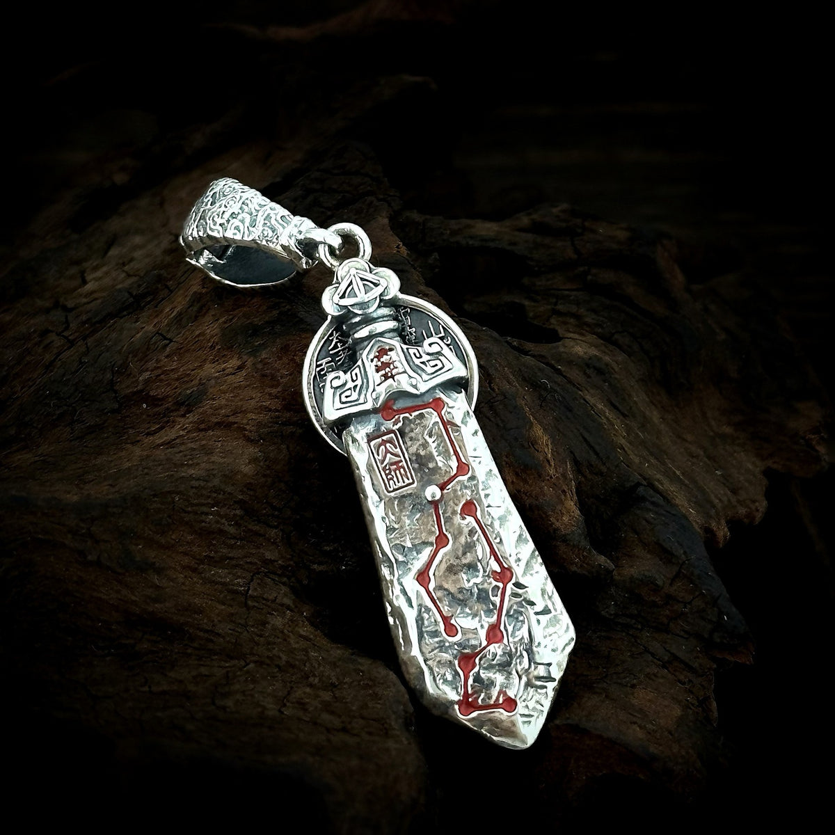 Front of the TaoWards Seven Star Sword Coin Pendant, shown on dark wood.